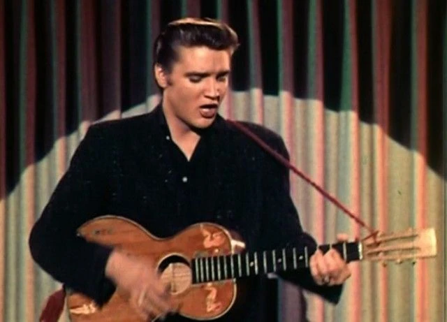 Elvis som står å synger Blue Suede Shoes med sin gitar